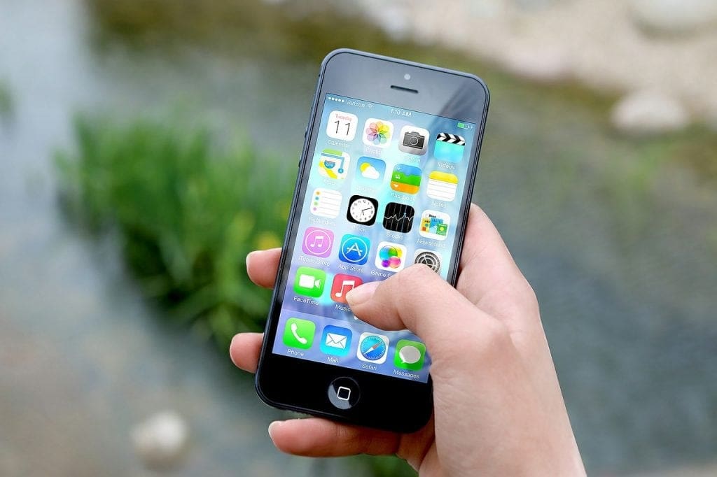 person holding iphone with apps